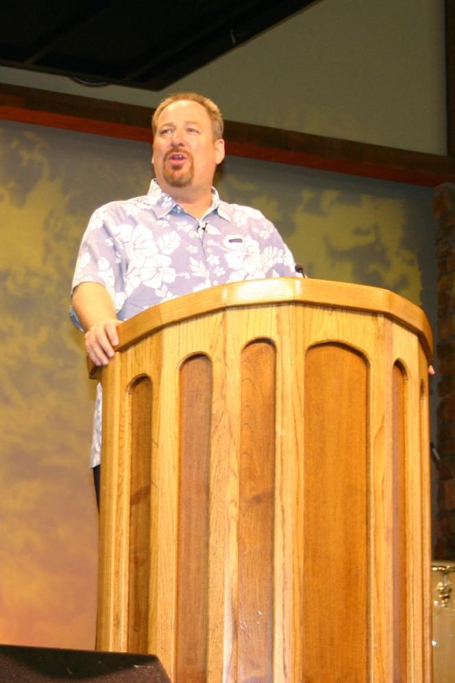 A white man standing at a podium