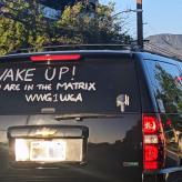 Writing on SUV rear window that reads "Wake Up! You are in the Matrix WWG1WGA"
