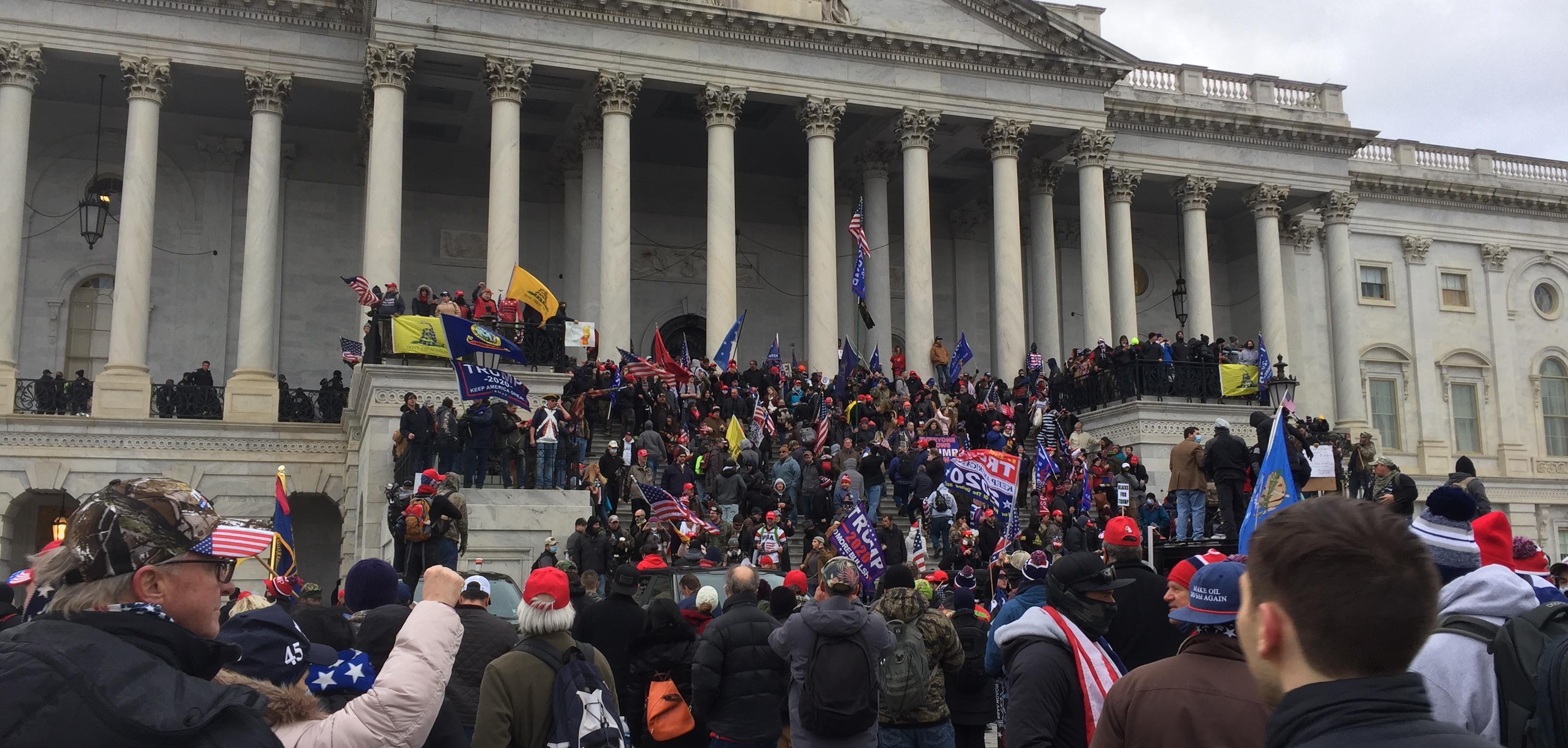 A group of right wing protesters outside the Capitol building in Washington DC. They are climbing the Stairs of the building.