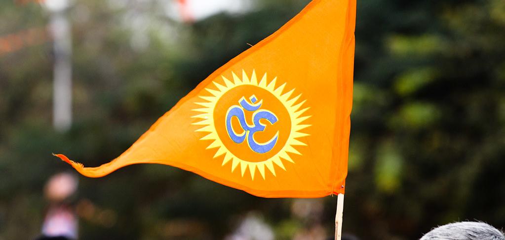 An orange triangle flag with an "Om" on it.