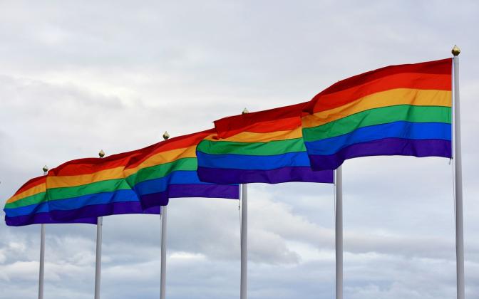 Five LGBTQ Flags flying in a row.