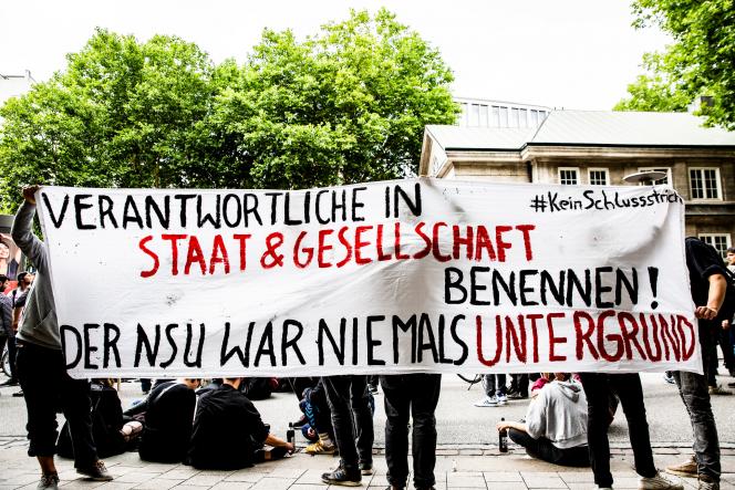 A group holding a white banner that reads: name those responsible in the state and society! The NSU was never underground