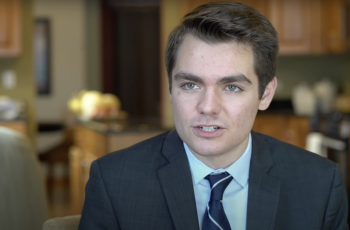 A young white man, Nick Fuentes, in a suit