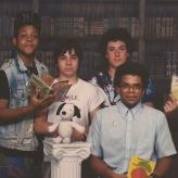 Young Eric Ward posing with friends holding books