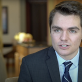 A young white man, Nick Fuentes, in a suit