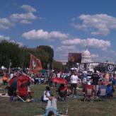 People standing in a field sporadically in front of the D.C capitol