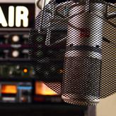 An illuminated "on air" sign and a microphone