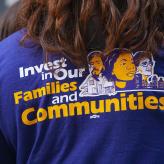 A T-shirt that reads "Invest in our families and communities"