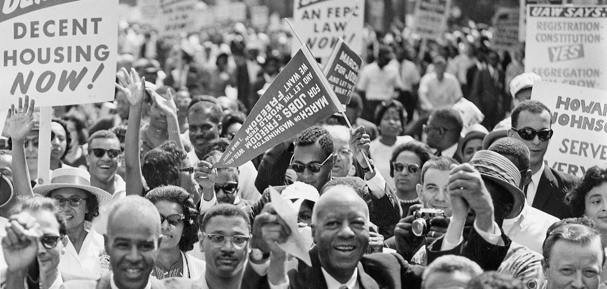 a group of people marching, holding signs.