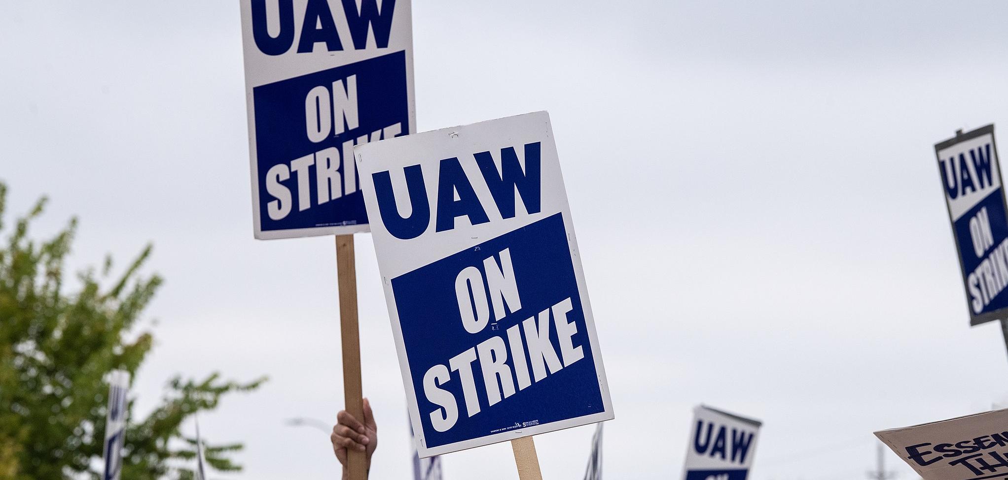 Protest signs that say "UAW on strike"