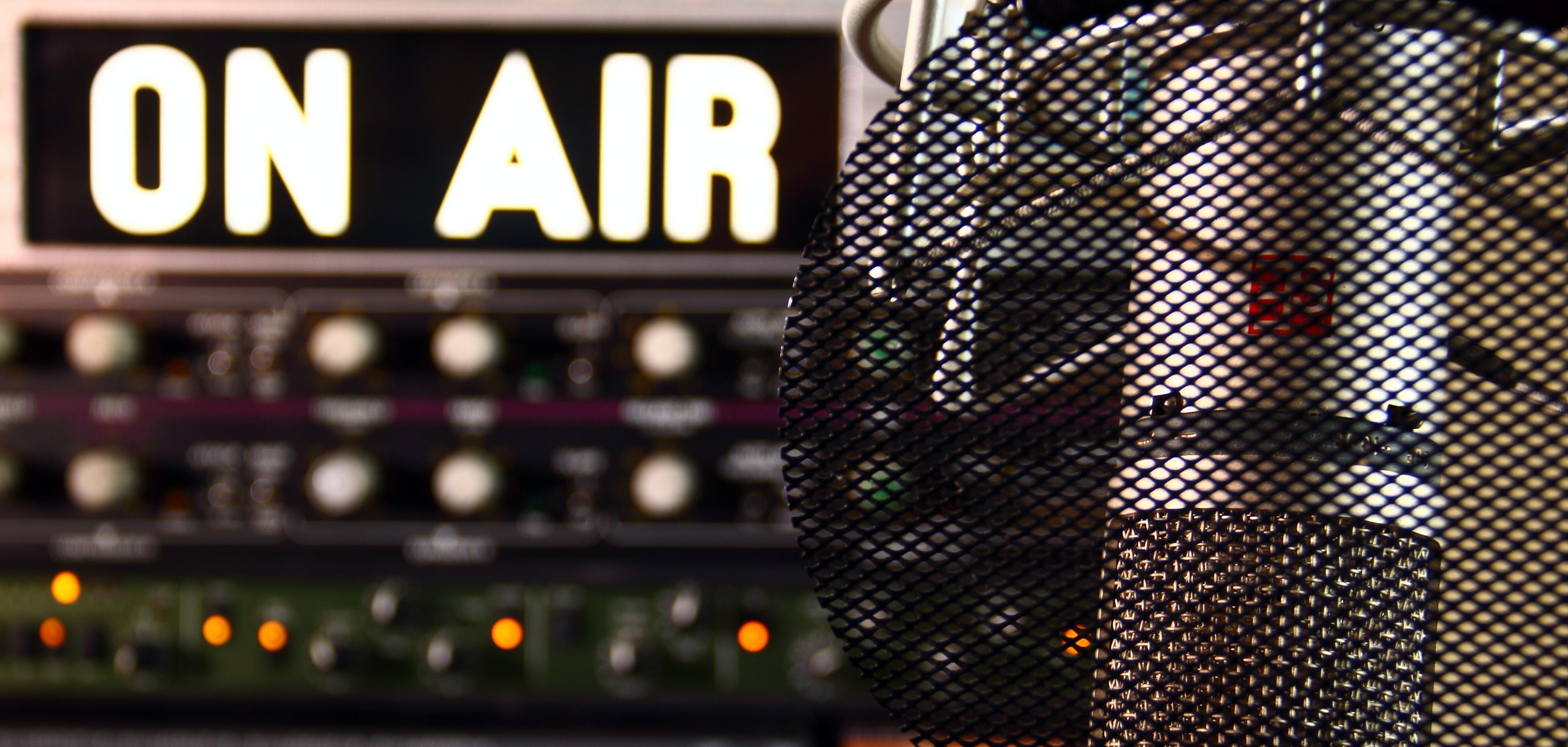 An illuminated "on air" sign and a microphone