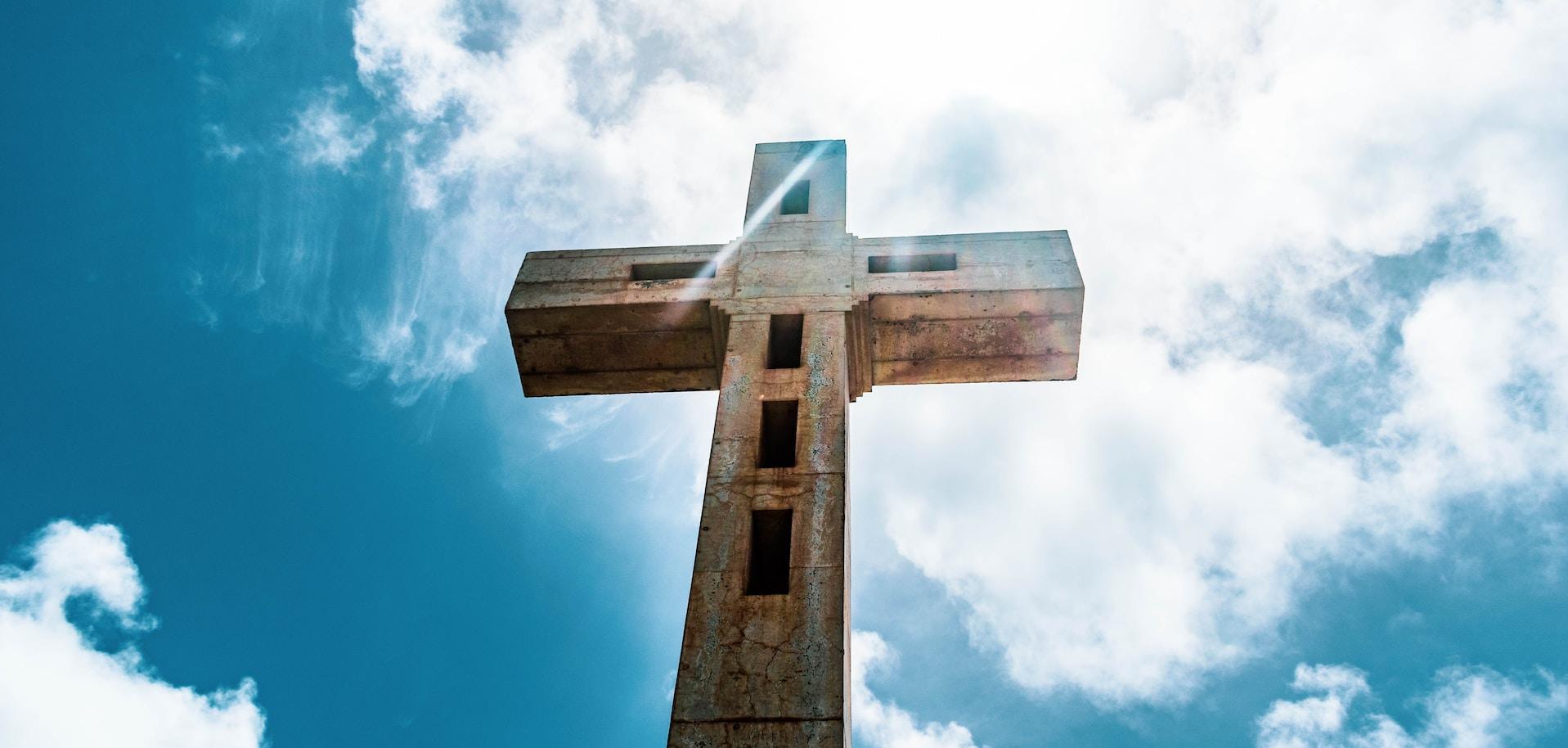 A wooden cross against a blue sky.
