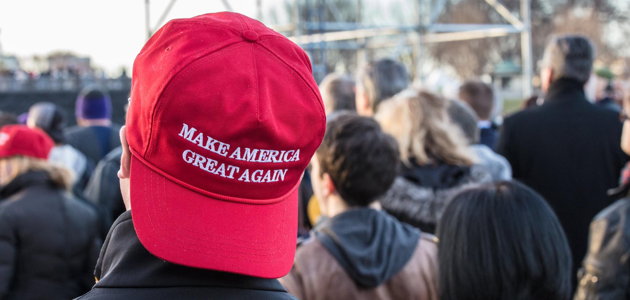 A Person wearing a MAGA hat backwards.