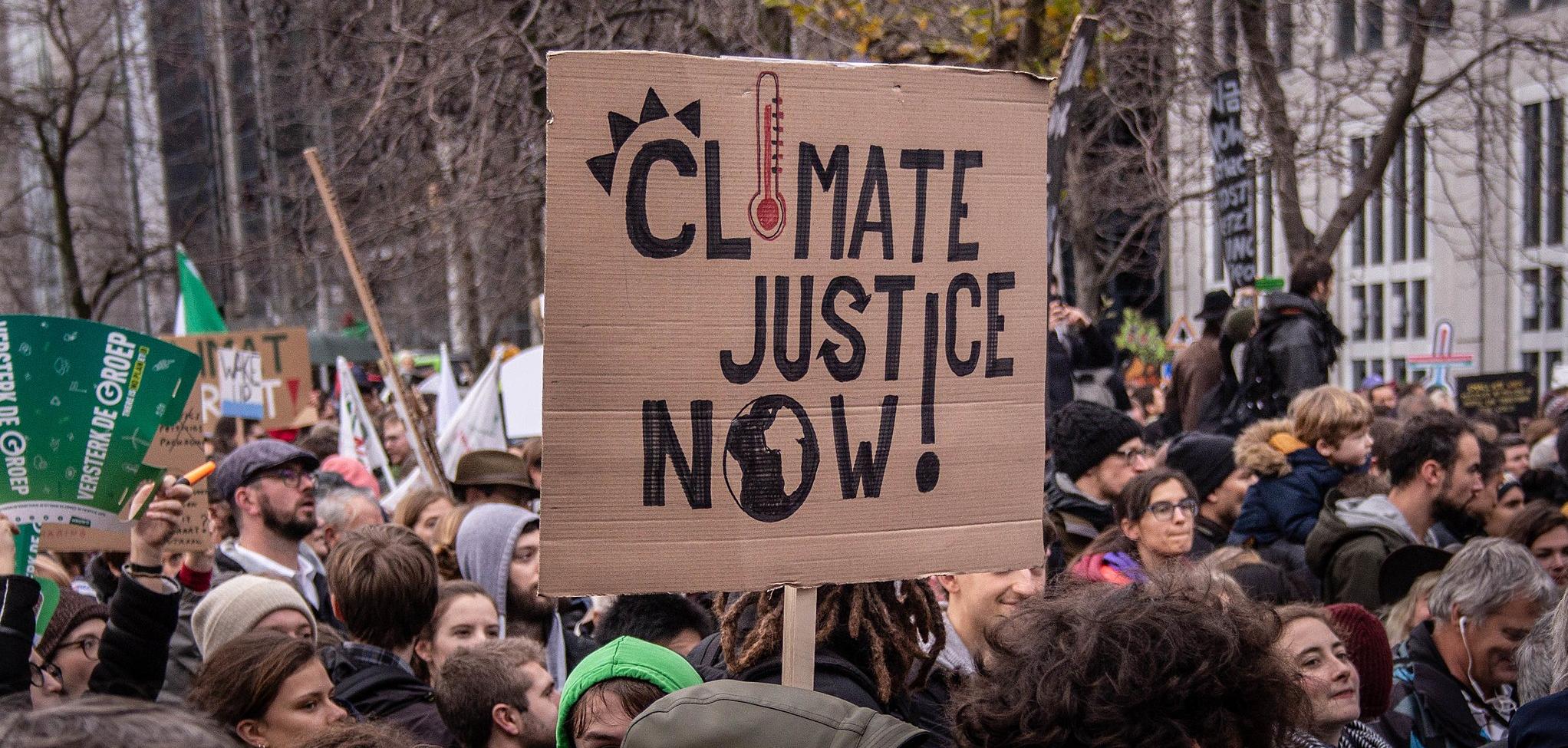 An protest sign that says "climate justice now!"